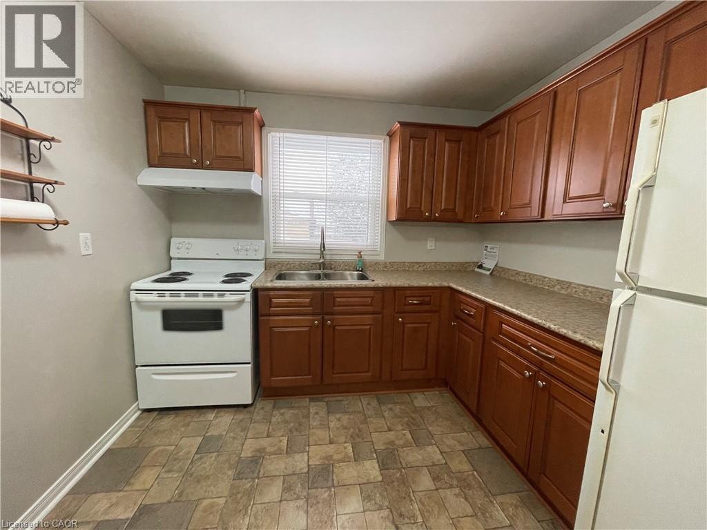 A kitchen with brown cabinets and a white stove.