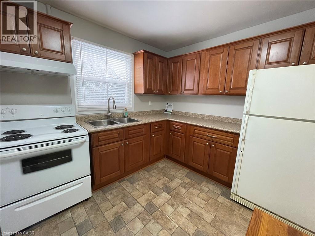 A kitchen with white appliances and brown cabinets.