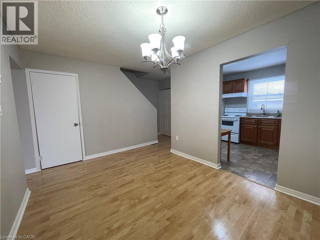 A room with wooden flooring and a chandelier.