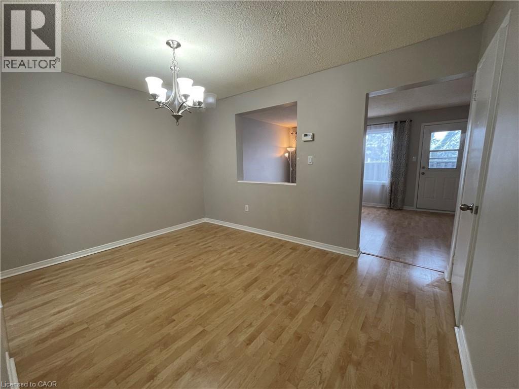 A room with wooden flooring and a chandelier.