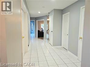 A hallway with white tile flooring and white walls.