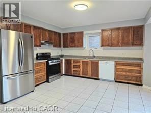 A kitchen with wooden cabinets and a stainless steel refrigerator.