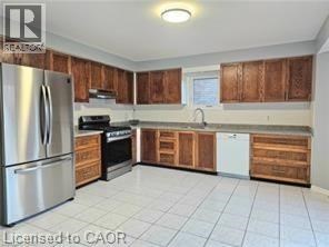 A kitchen with wooden cabinets and a stainless steel refrigerator.