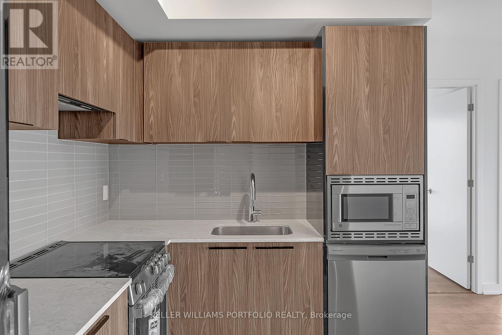 A kitchen with wooden cabinets and a stainless steel dishwasher.
