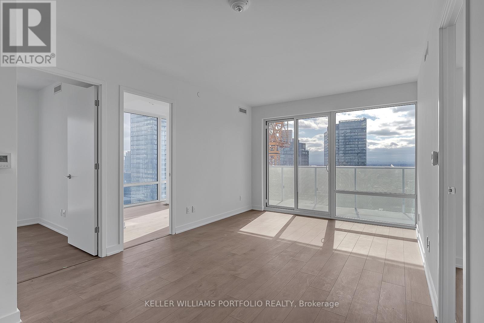 A spacious room with a view of the cityscape through the windows.