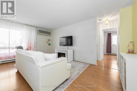 A living room with a white couch and a television on a white stand.