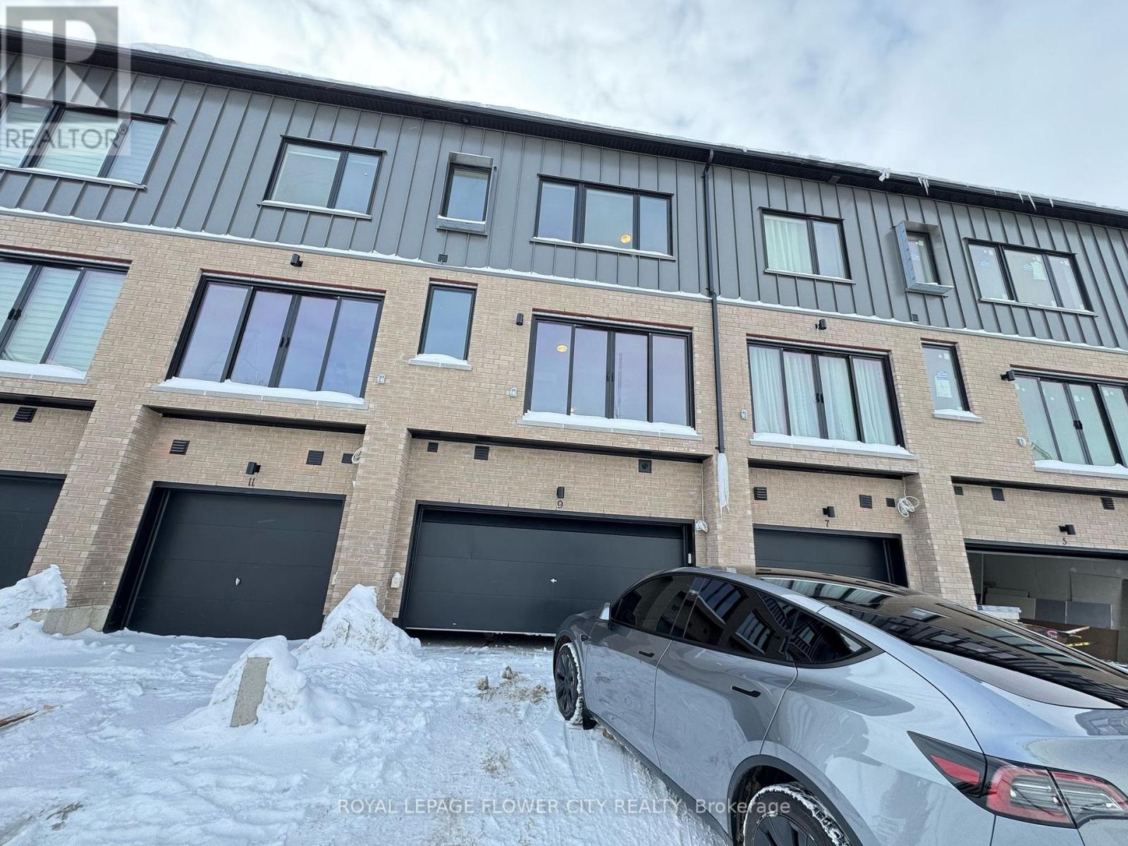 A car is parked in front of a building with a sign that reads "Royal LePage Flower City Realty.".