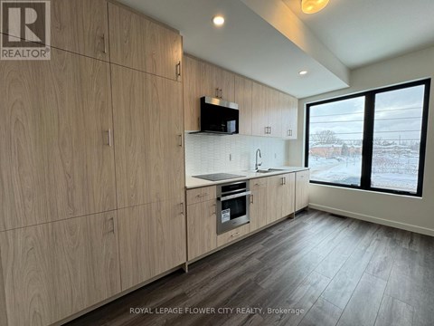 A kitchen with wooden cabinets and a microwave above the stove.