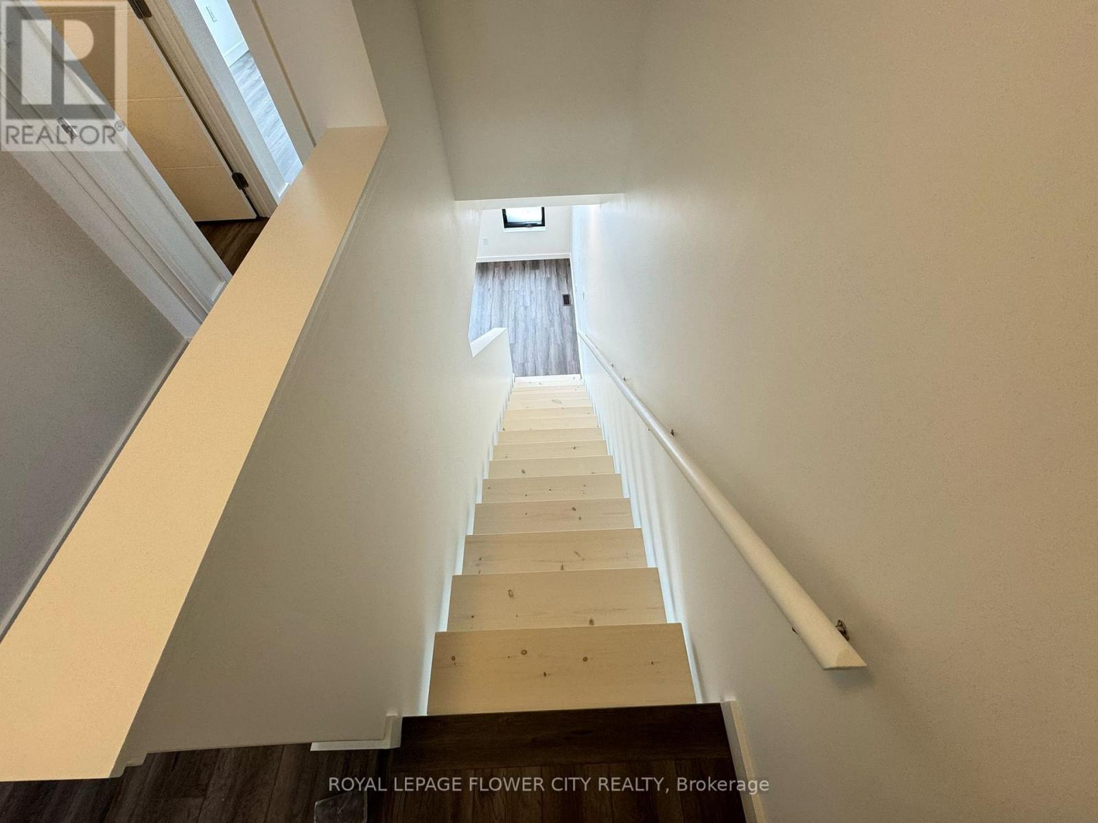 A staircase with a white railing and wooden steps leading to a doorway.