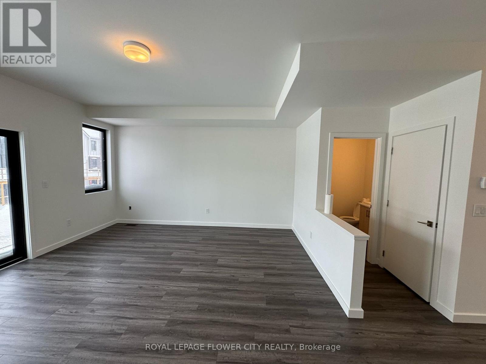 A spacious room with a grey floor and white walls.