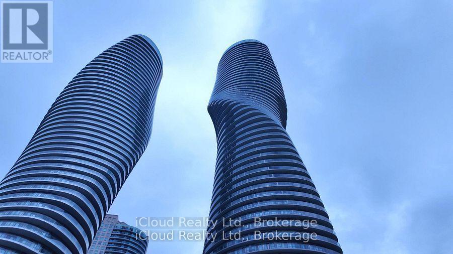 Two tall buildings with a blue sky in the background.