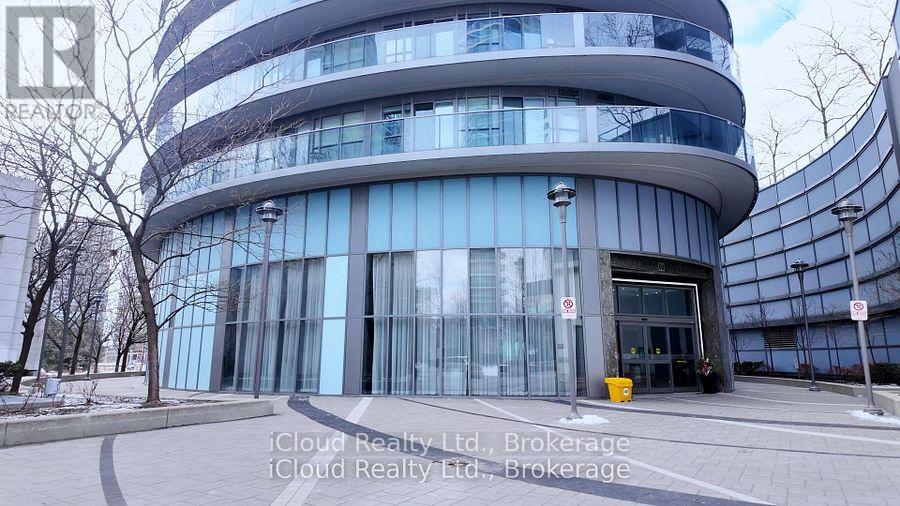 A modern building with a glass facade and a no parking sign in front.