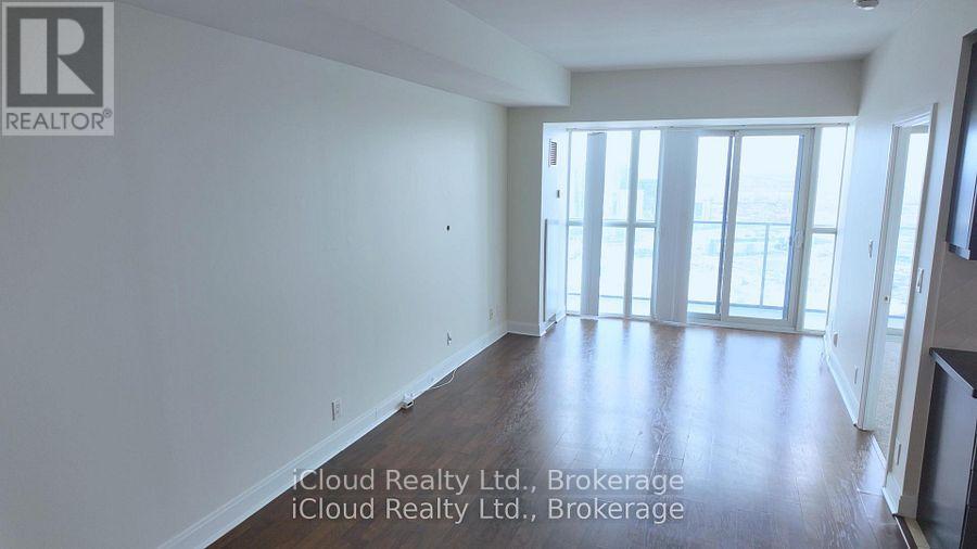 A room with wooden flooring and a large window.