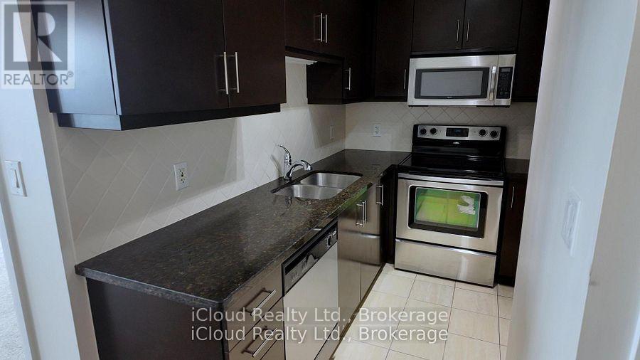 A kitchen with black cabinets and a stove top oven.