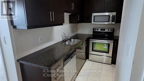 A kitchen with black cabinets and a stove top oven.
