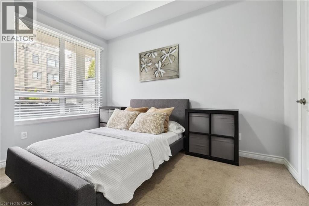 A bedroom with a large bed and a window with blinds.