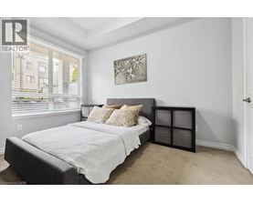 A bedroom with a large bed and a window with blinds.