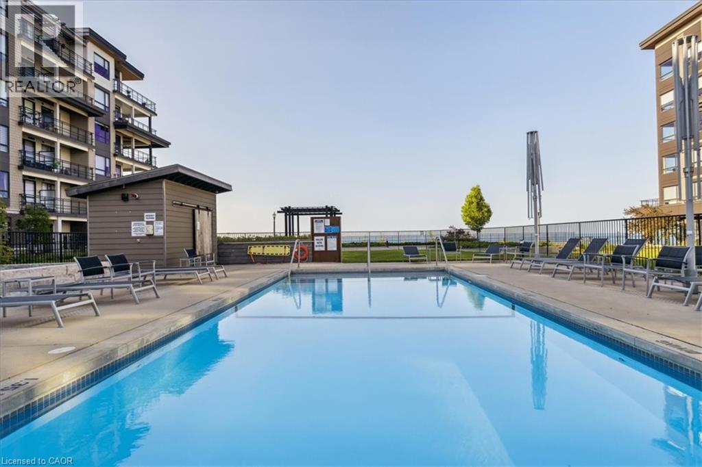 A swimming pool with lounge chairs and a building in the background.