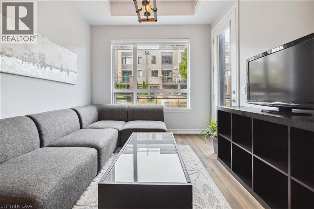 A living room with a grey couch and a coffee table in front of a large window.