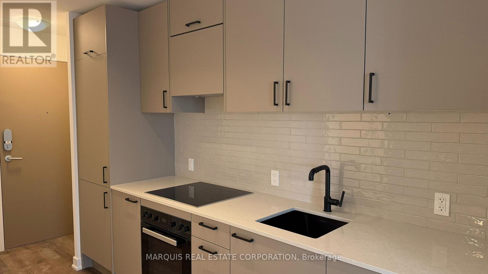 A kitchen with a sink and a stove top oven.