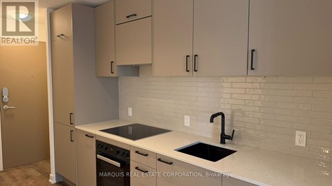 A kitchen with a sink and a stove top oven.