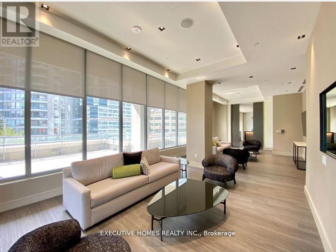 A well-lit, modern living room with a glass table and comfortable seating.