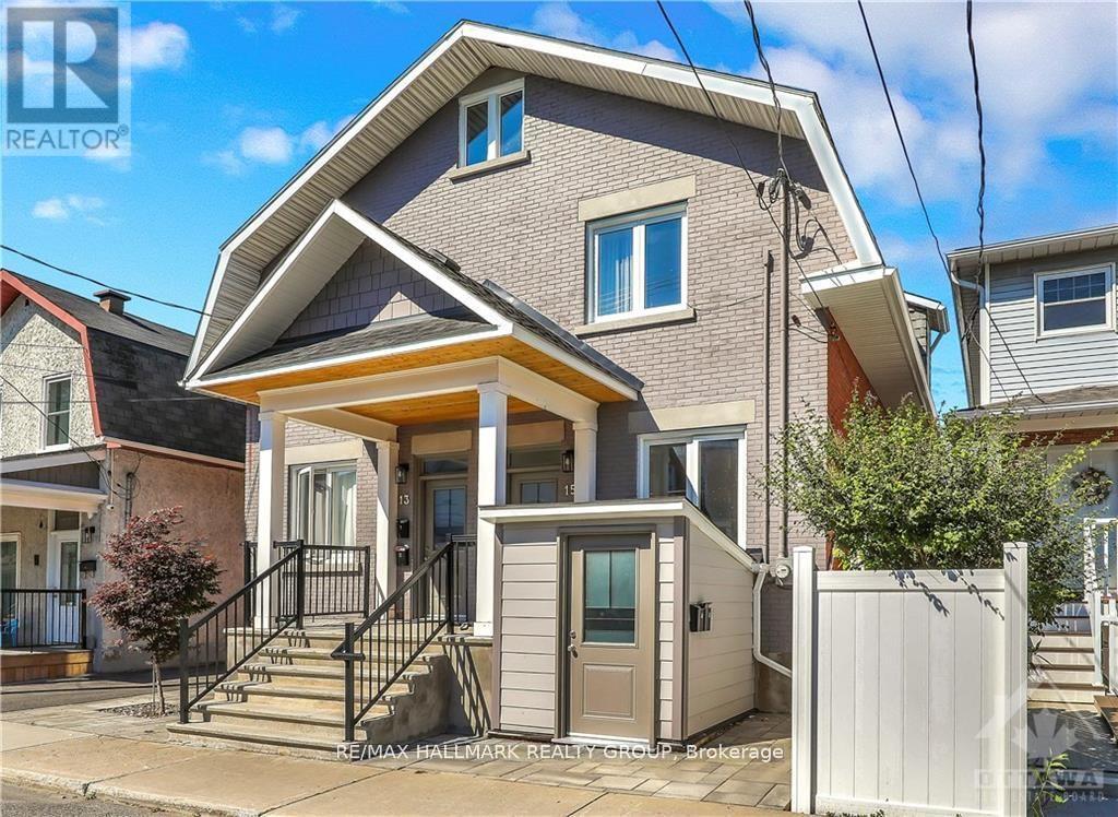 A two-story house with a front porch and a white fence.