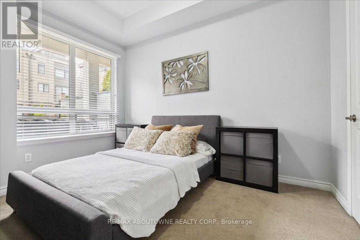 A bedroom with a bed, pillows, and a picture on the wall.