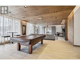 A spacious room with a pool table and a television.