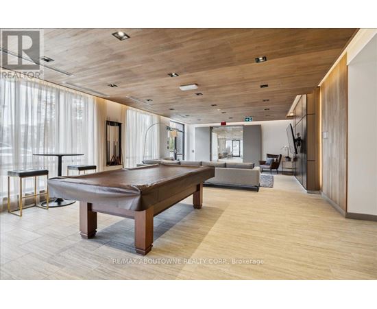 A spacious room with a pool table and a television.