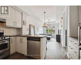 A modern kitchen with white cabinets and stainless steel appliances.
