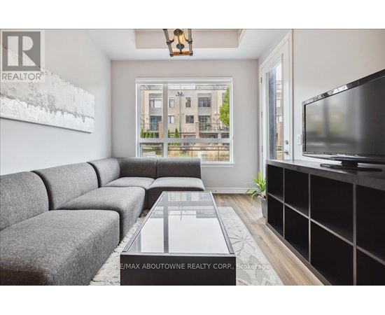 A living room with a grey couch and a large window.