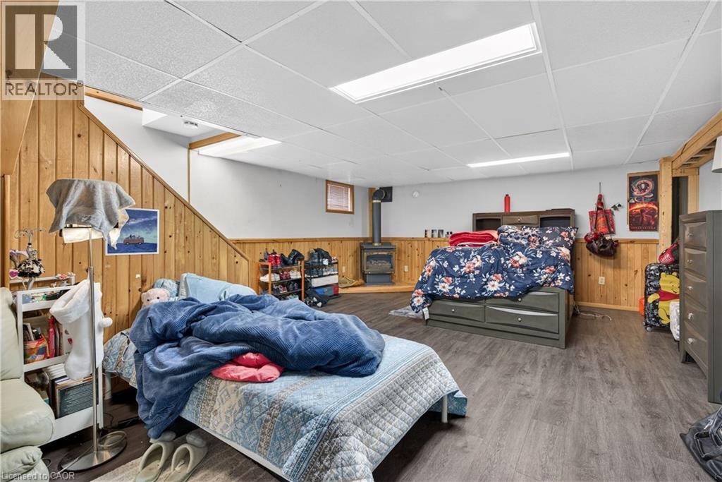 A bedroom with a bed covered in a blue comforter and a wooden wall.