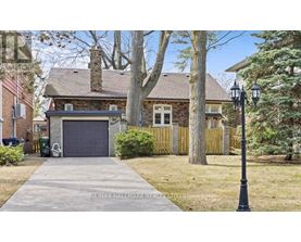 A house with a garage and a driveway in front of it.