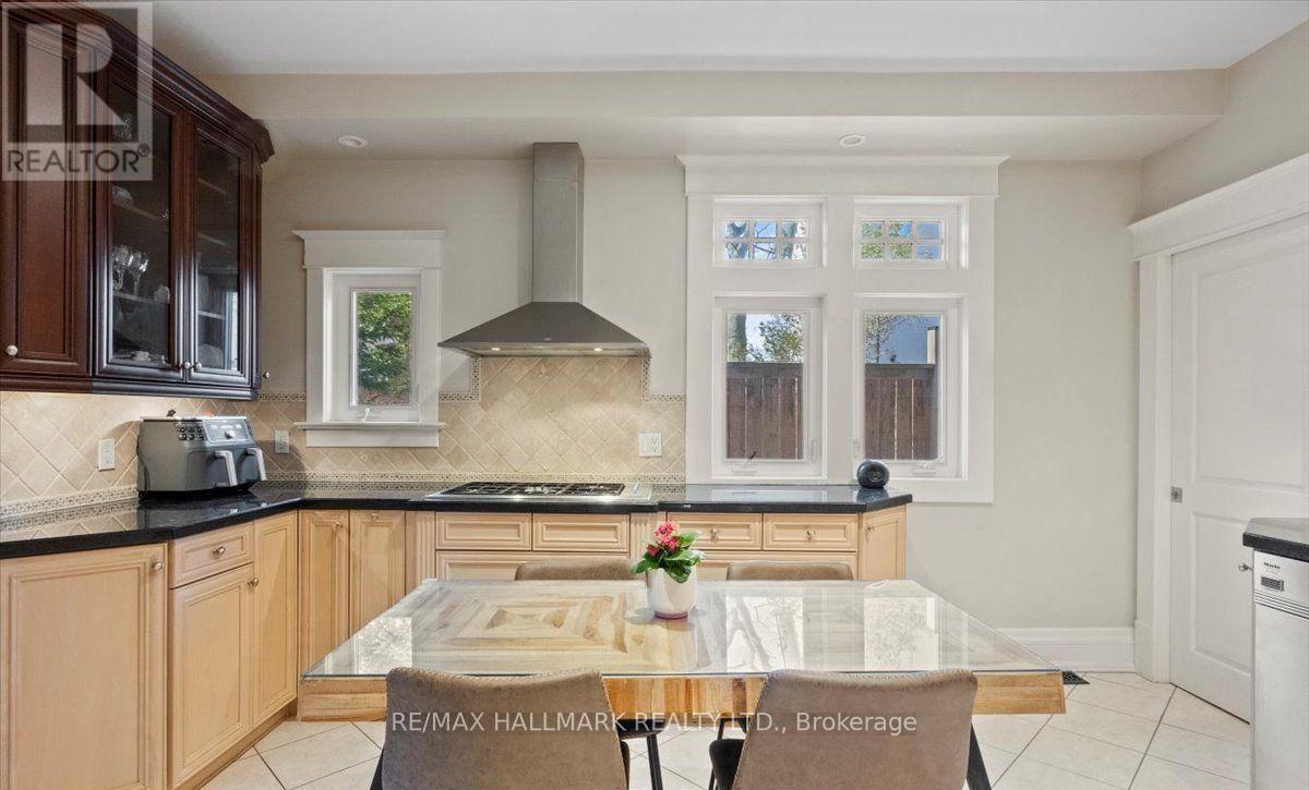 A kitchen with a glass table and a stove top oven.