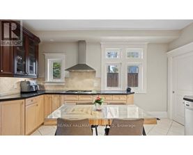 A kitchen with a glass table and a stove top oven.