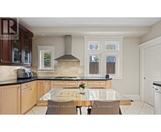 A kitchen with a glass table and a stove top oven.