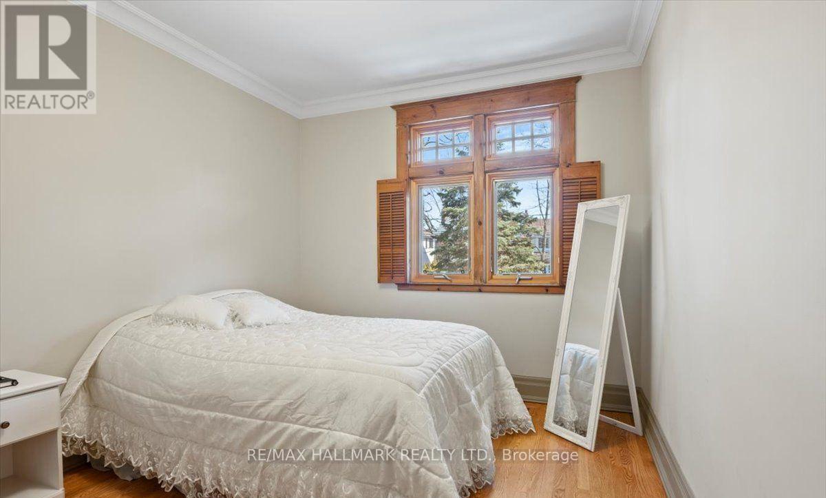 A bedroom with a bed, a window, and a white dresser.