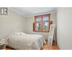 A bedroom with a bed, a window, and a white dresser.