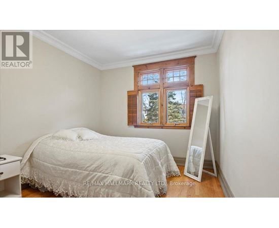 A bedroom with a bed, a window, and a white dresser.