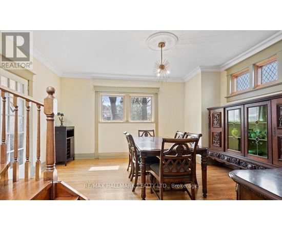 A dining room with a wooden table and chairs.