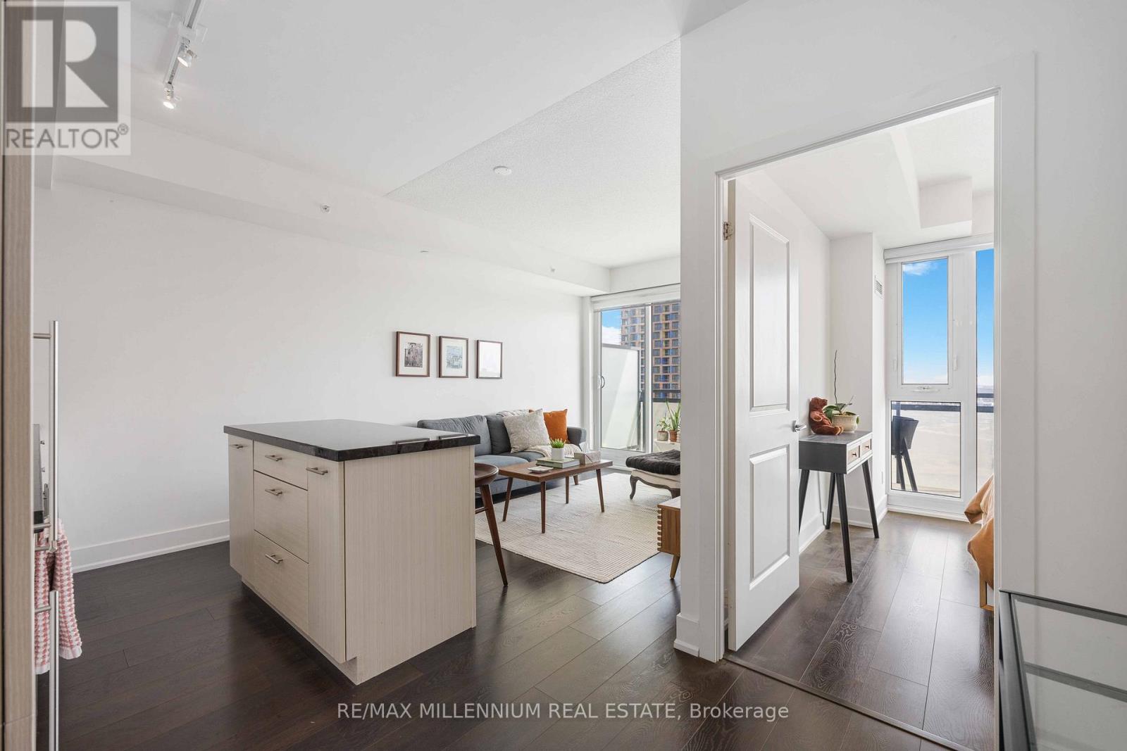 A kitchen with a black countertop and a dining area with a table and chairs.