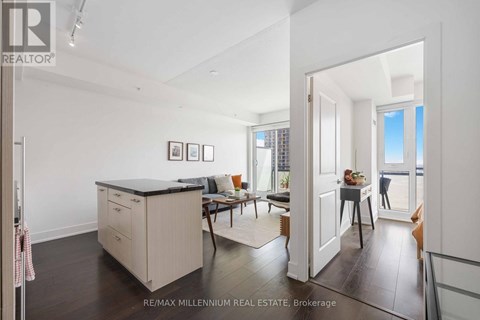 A kitchen with a black countertop and a dining area with a table and chairs.