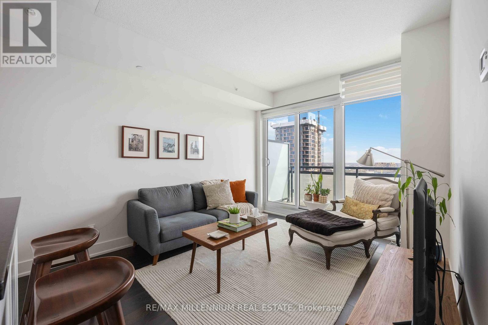 A living room with a grey couch, a coffee table, and a flat screen TV.