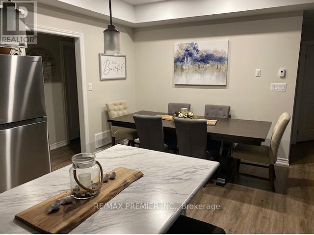 A dining room with a table, chairs, and a painting on the wall.