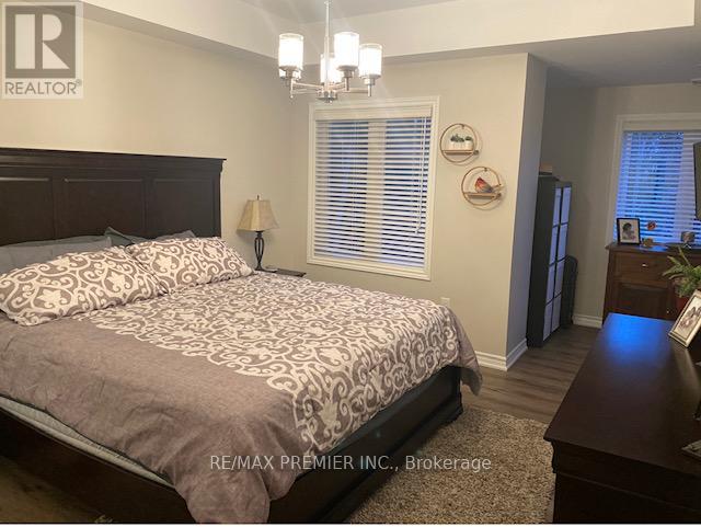 A bedroom with a large bed and a nightstand with a lamp.