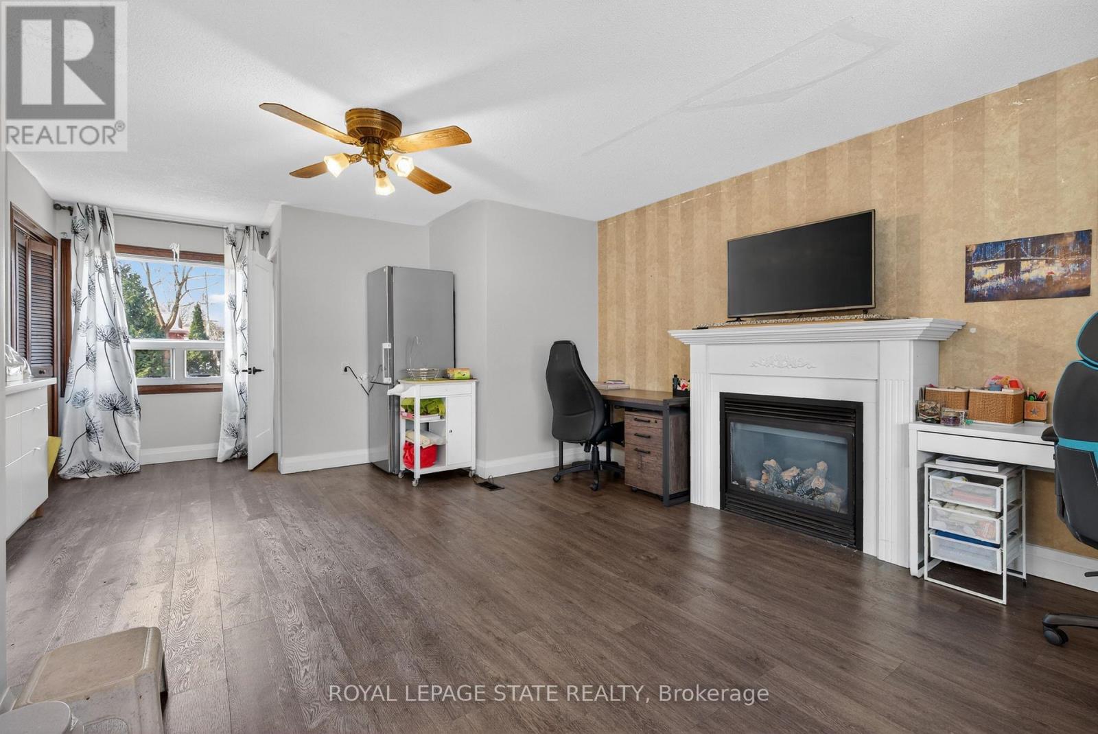 A living room with wood flooring and a fireplace.