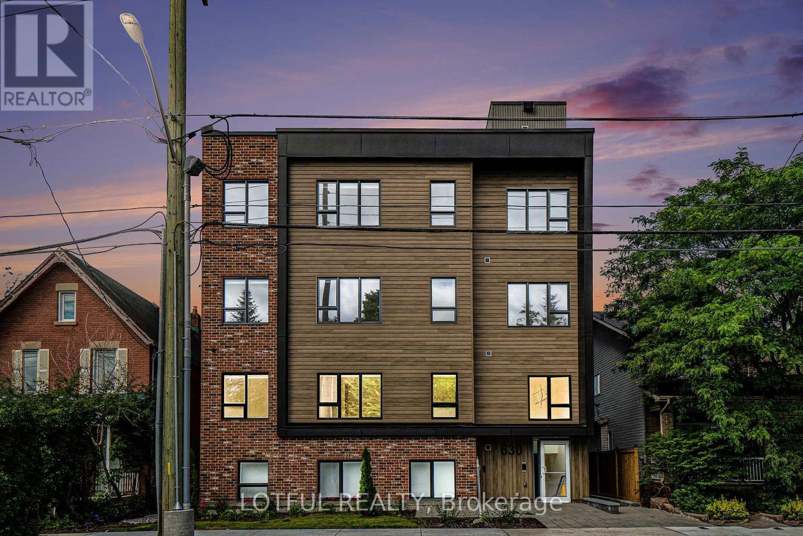 A modern two-story building with a brick facade and large windows.