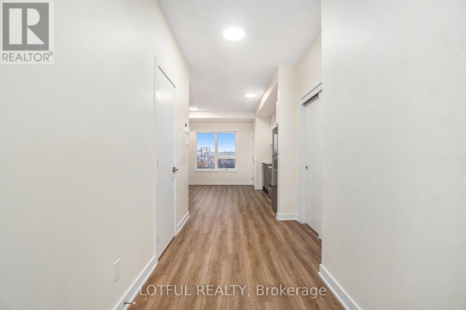 A long hallway with a view of the outside through the window.