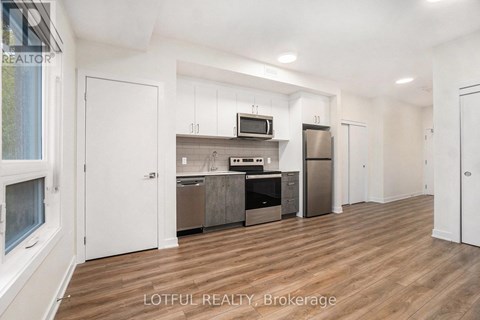 A spacious kitchen with white cabinets and stainless steel appliances.